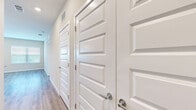 Located at 3030 Ascend Oak St in Apopka, FL, this well-appointed 2-bedroom, 2-bathroom single-floor home offers a thoughtfully designed layout with modern finishes throughout. The open-concept kitchen and living area serves as the heart of the home, featuring crisp white cabinetry, stainless steel appliances including a refrigerator, range, and microwave, a central island with a neutral-toned countertop, and pendant lighting overhead. Wood-look luxury vinyl flooring flows seamlessly through the main living areas, complementing the light, neutral color palette. Multiple windows fitted with white blinds allow natural light to fill the space. A private entrance door off the kitchen area adds convenience. The primary bedroom is generously sized, with plush carpeting, a ceiling fan, and windows on multiple walls. It connects to a spacious walk-in closet equipped with wire shelving systems for ample storage. The primary bathroom features a dual-sink vanity with white shaker cabinets, quartz-style countertops, framed mirrors, and wood-look flooring. The second bedroom also offers carpeted flooring with direct access to a full bathroom complete with a tub-shower combo. A bright hallway lined with clean panel doors connects the rooms, completing this functional and modern home.