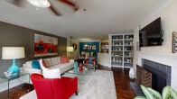 Located at 16204 Summerwood Ln in Alpharetta, GA, this single-story residence offers a thoughtfully designed open-concept layout that seamlessly connects the living, dining, and kitchen areas. The living room is a standout space, featuring rich hardwood-style flooring, crown molding, a tile-surround fireplace, a built-in bookcase, and a ceiling fan. Large windows invite abundant natural light, while the open sightline to the dining area enhances the sense of spaciousness. The galley-style kitchen is efficiently laid out with dark wood cabinetry, granite countertops, stainless steel appliances, and hardwood-style flooring, opening conveniently to the dining area accented by a bold teal feature wall and an elegant pendant light fixture. The primary bedroom offers plush carpeting, a teal accent wall, a ceiling fan, and a bright window with outdoor views, complemented by a private en-suite bathroom featuring dark wood vanity cabinetry and granite countertops. A second bedroom is equally well-appointed with warm golden-yellow walls and plush carpeting. The second full bathroom includes a full tub and shower combination with stylish tiled surroundings and hardwood-style flooring, completing this vibrant and well-designed home.