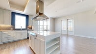 This well-appointed single-floor residence showcases a thoughtfully designed open-concept layout that seamlessly connects the kitchen, dining, and living areas. The kitchen serves as the heart of the home, featuring a large center island with a quartz countertop and integrated shelving, crisp white shaker cabinetry, a bold stainless steel island range hood, a full suite of stainless steel appliances, and a decorative tile backsplash. Light wood-look flooring flows throughout the main living areas, complementing the neutral, bright color palette.

The living area opens to the outdoors through French doors, allowing generous natural light to fill the space. A built-in desk and cabinetry station in one room provides a practical workspace. Bedrooms are finished with plush carpeting and feature ceiling fans and windows with exterior views, creating comfortable and well-lit retreats.

Two full bathrooms are finished with large-format tile flooring, white vanity cabinetry topped with granite countertops, and tub-shower combinations with curved curtain rods and clean tile surrounds. Throughout the residence, crisp white trim, recessed lighting, and a consistent neutral tone lend a modern, move-in-ready aesthetic.
