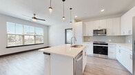 Located at 1400 Henderson St in Fort Worth, TX, this well-appointed 2-bedroom, 3-bathroom residence offers a thoughtfully designed single-floor layout. The open-concept kitchen and living area serves as the heart of the home, featuring a large center island with quartz countertops, an undermount sink, and stylish pendant lighting. White shaker cabinets, a herringbone tile backsplash, and stainless steel appliances — including a refrigerator, range, microwave, and dishwasher — complete the contemporary kitchen. The living area extends naturally from the kitchen, bathed in natural light from large windows, and includes a ceiling fan and direct access to a private balcony with city views. Luxury vinyl plank flooring flows throughout the main living spaces, while plush carpet adds comfort to the bedrooms. The generously sized primary bedroom features multiple windows with urban views, a ceiling fan, and access to two closets and a well-appointed en-suite bathroom with a glass-enclosed shower, wood-toned vinyl flooring, and a white vanity with ample storage. The second bedroom also enjoys abundant natural light and wood-look flooring. Additional highlights include a dedicated laundry area, a utility room, and two closets for enhanced storage throughout.