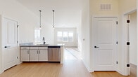 Located in Brentwood, TN, this well-designed three-bedroom, three-bathroom residence offers a thoughtfully planned single-floor layout. The open-concept kitchen serves as the heart of the home, featuring light wood cabinetry with matte black hardware, granite countertops, a full suite of stainless steel appliances including a refrigerator, range, microwave, and dishwasher, and stylish pendant lighting overhead. Light wood-look flooring flows throughout the main living and kitchen areas, creating a bright, cohesive aesthetic complemented by crisp white walls and abundant natural light from multiple windows. The living area extends seamlessly from the kitchen, offering an airy, connected feel. Each of the three bedrooms is finished with plush carpet flooring and large windows that invite natural light and outdoor views. A hallway connects the bedrooms to the bathrooms, which are finished with granite-topped vanities, wood-look flooring, and tiled tub-shower combinations featuring brushed nickel fixtures. A dedicated closet provides additional storage. The clean, contemporary design and quality finishes throughout make this Brentwood residence a comfortable and functional home.