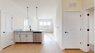 Located in Brentwood, TN, this well-designed three-bedroom, three-bathroom residence offers a thoughtfully planned single-floor layout. The open-concept kitchen serves as the heart of the home, featuring light wood cabinetry with matte black hardware, granite countertops, a full suite of stainless steel appliances including a refrigerator, range, microwave, and dishwasher, and stylish pendant lighting overhead. Light wood-look flooring flows throughout the main living and kitchen areas, creating a bright, cohesive aesthetic complemented by crisp white walls and abundant natural light from multiple windows. The living area extends seamlessly from the kitchen, offering an airy, connected feel. Each of the three bedrooms is finished with plush carpet flooring and large windows that invite natural light and outdoor views. A hallway connects the bedrooms to the bathrooms, which are finished with granite-topped vanities, wood-look flooring, and tiled tub-shower combinations featuring brushed nickel fixtures. A dedicated closet provides additional storage. The clean, contemporary design and quality finishes throughout make this Brentwood residence a comfortable and functional home.