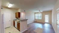 This 2-bedroom, 2-bathroom single-floor residence offers a practical and comfortable layout designed for easy living. The open-concept living and dining area is anchored by rich hardwood flooring and a ceiling fan, with large windows fitted with vertical blinds that allow generous natural light to fill the space. A sliding glass door provides direct outdoor access from the living area.

The kitchen features warm wood cabinetry, granite-style countertops, white appliances including a refrigerator, dishwasher, and microwave, and a peninsula that opens to the main living space, making it ideal for everyday use and casual entertaining.

Both bedrooms are carpeted and equipped with ceiling fans and windows with vertical blinds. The primary bedroom includes a walk-in closet, offering ample storage. The two bathrooms are finished with tile flooring and wood-toned vanity cabinetry. The primary bathroom features an extended vanity with a large mirror, while the second bathroom offers a compact, efficiently designed layout.

Neutral warm tones throughout the unit create a cohesive and inviting ambiance, complemented by consistent finishes across all rooms. The floor plan is thoughtfully organized to maximize functionality within the available space.