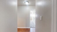 This one-bedroom, one-bathroom apartment at 1712 Carver Rd in Modesto, California offers a clean, functional layout across a single floor. The entryway features rich hardwood-style flooring and a textured ceiling, leading into the main living areas with a bright, neutral palette throughout.

The kitchen is a standout feature, showcasing updated grey cabinetry with modern hardware, light quartz-style countertops, and stainless steel appliances including a range and refrigerator. The hardwood-style flooring continues through this space, complementing the contemporary cabinetry tones.

The living area is generously proportioned, finished with plush grey carpeting and a textured ceiling. A sliding glass door fills the room with natural light and provides direct access to a private balcony, adding an outdoor element to the living space. A wall-mounted air conditioning unit ensures year-round comfort.

The bedroom is carpeted and well-lit by a large window fitted with blinds, offering natural light and outdoor views. A wall unit provides additional climate control.

The bathroom is neatly appointed with a combined tub and shower enclosed by sliding glass doors, a vanity with grey cabinetry, and hardwood-style flooring that ties the space together cohesively. The overall aesthetic is clean, updated, and move-in ready.