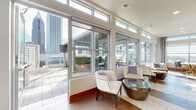 Located in the heart of Midtown Atlanta at 782 Peachtree St NE, this sophisticated lounge and event space offers an exceptional blend of modern interior design and striking urban panoramas. The interior lounge area is bathed in natural light, courtesy of floor-to-ceiling windows and transom glass panels that frame sweeping views of Atlanta's iconic skyline. Elegant white upholstered seating, tile flooring, and polished metallic accent tables create a refined yet welcoming atmosphere throughout.

The fully equipped kitchen is a standout feature, showcasing warm wood cabinetry, a mosaic tile backsplash, crisp white countertops, and stainless steel appliances. A spacious island with brick-tile detailing and bar seating makes it ideal for catering or social gatherings, while amber glass pendant lights add a warm, contemporary touch.

A cozy dining nook with expansive city-facing windows provides an intimate setting with broad views of the Midtown skyline and beyond. The space seamlessly connects to a generously sized outdoor terrace, complete with a wood-beamed pergola, lush planted greenery, and comfortable lounge furniture — perfect for alfresco gatherings set against Atlanta's urban backdrop.