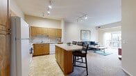 Located at 1745 Graham Ave in Saint Paul, Minnesota, this well-appointed two-bedroom, one-bathroom home offers a thoughtfully designed single-floor layout. The open-concept kitchen and living area serves as the heart of the space, where warm honey-toned cabinetry, ample counter space, and a center island with bar seating create a functional and inviting environment. Track lighting illuminates both the kitchen and living room, enhancing the bright, neutral palette throughout. The kitchen is equipped with a full suite of appliances, including a range, microwave, dishwasher, and refrigerator, alongside generous upper and lower cabinet storage. The living area features plush carpeting and a comfortable, open feel. The primary bedroom is a standout, offering sliding glass door access to a private balcony with outdoor views, along with a dedicated closet. The second bedroom benefits from a large window that fills the room with natural light and includes its own closet. Three total closets throughout the home provide substantial storage. The full bathroom features tile flooring, a single-sink vanity with wood cabinetry, and a shower/tub combination. Two hallways connect the home's spaces efficiently, and the overall neutral, warm tones lend a clean and cohesive ambiance throughout.