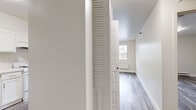 Located at 666 Third St in Albany, NY, this single-floor, one-bedroom, two-bathroom unit offers a thoughtfully designed layout that maximizes its compact footprint. The interior presents a cohesive, freshly updated aesthetic characterized by neutral white walls, clean white baseboards, and gray wood-style vinyl plank flooring that runs consistently throughout the space.

The combined living and kitchen area forms the heart of the unit. The kitchen is outfitted with white shaker-style cabinetry, white countertops, a stainless steel refrigerator, and white appliances, giving it a bright, organized appearance. The adjacent living area provides an open, versatile space filled with natural light.

The bedroom is a comfortable, well-proportioned room featuring a large window that brings in natural light and outdoor views of surrounding trees. A built-in closet with shelving offers practical storage.

Both bathrooms are finished in a clean, all-white palette. One bathroom includes a full tub-shower combination with tiled surround, chrome fixtures, and a white vanity. The unit also includes a dedicated utility area housing a water heater. Baseboard heating is present throughout, contributing to the space's functional, move-in-ready appeal.