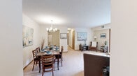 Located at 1272 Birch Point in Eagan, Minnesota, this single-floor residence offers a thoughtfully organized layout encompassing one bedroom, two bathrooms, a dedicated office, and in-unit laundry. The living room is bright and welcoming, featuring plush carpeting, neutral tones, and wood-trimmed sliding glass doors that open to a private balcony with outdoor views, filling the space with natural light. The galley-style kitchen is efficient and well-equipped, featuring white cabinetry with wood accents, white appliances, and tile flooring that flows into the adjacent dining area. The dining room is an inviting space anchored by a chandelier and complemented by soft carpet and clean walls. The spacious primary bedroom offers a large wood-trimmed window, carpeted floors, a walk-in closet with direct access to the in-unit laundry area. The office provides versatile additional space with a large window, closet, and outdoor views. Both bathrooms are well-appointed, featuring tile flooring, vanities with wood accents, and a tub-shower combination. The dedicated laundry room includes a top-loading washer, additional appliances, and overhead shelving for storage. Throughout the home, a consistent warm, neutral palette creates a cohesive and comfortable ambiance.