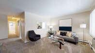 Located at 34800 Vine St in Eastlake, Ohio, this single-floor unit offers a well-organized layout designed for comfortable everyday living. The living room serves as the heart of the space, featuring plush carpeted flooring, neutral-toned walls, and large windows dressed with vertical blinds that allow ample natural light to filter in. A baseboard heating system and wall-mounted air conditioning unit ensure year-round climate comfort. The kitchen is thoughtfully designed with white cabinetry, a dark stone-style countertop, and light tile flooring. A standout architectural detail is the pass-through window that visually connects the kitchen to the living area, creating an open and communicative feel between spaces. The kitchen dining area accommodates a bistro-style setup, ideal for casual meals. The bedroom is a restful retreat with soft carpet underfoot, a sizable window with vertical blinds providing natural light, and sufficient space for full-sized furniture. The full bathroom is clean and bright, featuring white tile work, a wide vanity with a large mirror, and a shower-tub combination with a window for ventilation. Throughout, the unit maintains a cohesive, understated aesthetic with neutral tones and functional design elements.