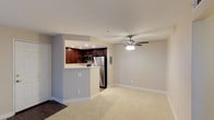 This single-floor, two-bedroom, two-bathroom residence offers a well-designed open layout that maximizes the sense of space throughout. The living area is finished with plush wall-to-wall carpeting and features a ceiling fan with integrated lighting, contributing to a comfortable and functional atmosphere. Neutral-toned walls throughout create a clean, versatile backdrop that adapts easily to a variety of décor styles.

The kitchen is set slightly apart from the living space, distinguished by rich dark-wood cabinetry that provides ample storage. It is equipped with stainless steel appliances, including a refrigerator and microwave, and features recessed lighting above the workspace. A pass-through counter connects the kitchen to the living area, promoting an open, communicative flow between spaces while maintaining a defined cooking zone. The flooring transitions from hard surface in the kitchen to soft carpeting in the main living area, creating a natural boundary between the two zones.

Overall, this residence combines practical functionality with a clean, modern aesthetic, offering a comfortable living environment across its two bedrooms and two full bathrooms.