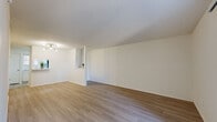 This single-floor residence offers a thoughtfully designed layout that balances open communal spaces with comfortable private areas. The spacious living room is finished with light-toned hardwood-style flooring and crisp white walls, creating a bright and airy atmosphere. A textured ceiling adds character throughout, while a ceiling fan provides functional comfort. A sliding glass door leads directly to a private outdoor patio, inviting natural light and seamless indoor-outdoor access.

The galley-style kitchen is efficiently arranged with white cabinetry, white countertops, and a classic subway tile backsplash. It is equipped with stainless steel appliances including a refrigerator, dishwasher, microwave, and electric range, providing a fully functional cooking space.

The bedrooms are carpeted for warmth and comfort, each featuring windows with blinds that allow for natural light and privacy. Ample storage is provided through generous closet space, including a walk-in closet outfitted with double hanging rods and shelving.

The bathrooms are clean and functional, each featuring a vanity with a single sink, white cabinetry, and a tub-shower combination with tiled surround. Light hardwood-style flooring carries through these spaces, maintaining a cohesive aesthetic throughout the home.