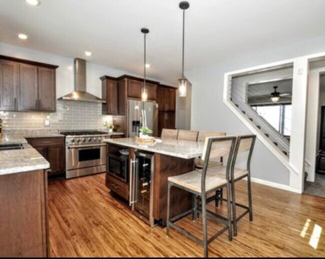 Cocina renovada con electrodomésticos de acero inoxidable y una isla con asientos. - 2328 Primrose St