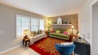 This 490 square foot home in North Charleston, SC, offers a thoughtful blend of compact living and stylish design. The single-story layout comprises one bedroom, one bathroom, and a well-appointed living area. The primary bedroom, measuring 170 square feet, features a ceiling fan, large window, and ample space for a queen-sized bed and additional furniture.

The living room is the heart of the home, showcasing a striking exposed brick wall that adds character and warmth. Large windows flood the space with natural light, while a mix of colorful furnishings creates a lively atmosphere. A vibrant red area rug with gold patterns anchors the room, complemented by a green sofa and blue accent chair.

The bathroom, though compact, is efficiently designed with white fixtures, a shower/tub combination, and a floral shower curtain that adds a touch of whimsy. The home's neutral wall colors provide a versatile backdrop for personalization, while wood-look flooring throughout unifies the space.

A notable feature is the home's use of ceiling fans, enhancing air circulation and comfort. The property's layout, as seen in the 3D floor plan, demonstrates clever use of the available square footage, creating distinct zones for living, sleeping, and bathing within the compact footprint.