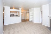 Located at 9500 Osuna Rd NW in Albuquerque, New Mexico, this single-floor residence offers a thoughtfully designed layout with a blend of comfort and functionality. Crown molding throughout lends a refined architectural touch, while neutral tones and abundant natural light from multiple windows create a bright and welcoming ambiance.

The open-concept living area features plush carpeting and connects seamlessly to the kitchen via a pass-through bar counter. The kitchen is equipped with stainless steel appliances — including a refrigerator, electric range, and over-the-range microwave — complemented by white cabinetry and granite-style countertops. Hardwood-style flooring runs through the kitchen and connecting areas, adding warmth and contrast.

The living room is spacious, with a fireplace and direct access to an exterior door, adding both charm and convenience. A built-in shelving unit provides practical storage and display space. The bedroom features a ceiling fan with a tray ceiling detail and generous windows that allow for ample natural light.

The bathrooms are well-appointed with soaking tubs, tiled surrounds, and granite-style vanity countertops. A dedicated in-unit laundry area houses a full-size washer and dryer, offering added everyday convenience. Overall, this residence combines practical amenities with clean, comfortable design.