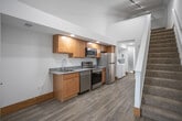 Located in Hudsonville, Michigan, this multi-level property spans three floors and offers a well-organized layout with practical finishes throughout. The kitchen is a standout feature, equipped with warm-toned wood cabinetry, granite countertops, and a full suite of stainless steel appliances including a refrigerator, electric range, microwave, and dishwasher. Wood-look plank flooring runs through the kitchen and main-level areas, complemented by recessed and track lighting overhead.

A dedicated laundry area is conveniently situated adjacent to the kitchen, housing a full-size top-loading washer and dryer alongside a water heater. The bathroom features a granite-topped vanity with wood cabinetry, a soaking tub with shower, and wood-look flooring that ties in with the rest of the home.

Upper and lower levels feature neutral-toned carpet with warm wood baseboards, providing a comfortable and cohesive aesthetic. One upper level showcases a striking vaulted, angled ceiling that adds architectural interest and an open, airy feel to the space. Carpeted staircases connect all three floors, with open areas on each level offering flexible use as living, sleeping, or recreational spaces.