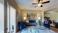 Located at 831 Cedar Lake Rd in Biloxi, Mississippi, this single-story home offers a thoughtfully designed layout that balances comfort and functionality. The living room serves as the heart of the home, featuring warm neutral walls, rich hardwood flooring, a ceiling fan, and an arrangement of gold-framed decorative mirrors that add depth and elegance to the space. An open sightline connects the living area to a dedicated dining space, promoting a seamless flow throughout. The kitchen is outfitted with dark wood cabinetry, crisp white countertops, a double stainless steel sink, and stainless steel appliances, offering both style and practicality. The bedrooms provide comfortable retreats, each with plush carpeting, ceiling fans, and ample natural light streaming through large windows. Generous closet space is featured in the bedrooms, adding to the home's storage capacity. The bathrooms are well-appointed with modern vanities, updated lighting, and a full tub-shower combination. A dedicated laundry room with a full-size washer and dryer and overhead shelving adds everyday convenience. Throughout the home, consistent warm-toned walls and hardwood-style flooring create a cohesive, inviting ambiance.