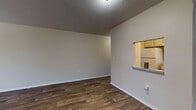 Located at 4300 18th St W in Bradenton, Florida, this single-floor unit offers a practical and comfortable layout designed for everyday living. Wood-style plank flooring runs throughout the main living areas, complemented by neutral-toned walls and textured ceilings that lend a classic Florida residential feel.

The living area is open and well-proportioned, featuring a distinctive pass-through window that connects it to the kitchen, allowing for easy interaction and added light between the two spaces. A hallway with a louvered bifold door provides access to additional areas of the unit, including closet storage.

The kitchen is efficiently designed with white upper and lower cabinetry offering ample storage, a double-basin sink positioned beneath a window, a white electric range with overhead ventilation, and durable wood-style flooring. Natural light filters in through the window, brightening the workspace.

The bedroom is generously sized with plush carpeting underfoot and a window overlooking greenery outside, providing a quiet, comfortable retreat. The bathroom includes a tub-shower combination and essential fixtures in a compact, functional layout.

Throughout the unit, the design prioritizes practicality with consistent finishes, ceiling-mounted light fixtures, and well-placed ventilation. This single-story residence offers a straightforward and livable floor plan in a convenient Bradenton location.
