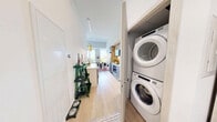 Located at 485 Perth Ave in Toronto's vibrant Junction neighbourhood, this thoughtfully designed one-bedroom, one-bathroom unit makes excellent use of its compact footprint across a single floor. The open-concept layout connects the kitchen, dining, and living areas seamlessly, creating a functional and inviting atmosphere.

The galley-style kitchen is outfitted with light wood cabinetry, integrated appliances, a white countertop, and an adjacent bar-height dining counter adorned with striking gold pendant lights — a refined focal point that adds warmth and character.

The living room is a standout space, featuring soaring ceilings and expansive floor-to-ceiling windows that flood the room with natural light and offer open views of surrounding greenery. The bright, airy ambiance makes the space feel generously proportioned.

The bedroom is a calm retreat with recessed lighting, large sliding panel closets finished in light wood, and clean white walls. Its cozy scale is complemented by a well-considered layout that maximizes utility.

The bathroom features large-format light tile flooring, a modern vanity with wood-toned upper cabinetry, a backlit mirror, and a shower-tub combination. Light wood-toned sliding doors and pale hardwood flooring throughout the unit tie each space together with a cohesive, contemporary aesthetic.