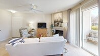 Located at 4129 Hearthside Dr in Wilmington, NC, this well-appointed 2-bedroom, 3-bathroom home offers a comfortable and cohesive coastal aesthetic throughout. The open living and dining area serves as the heart of the home, featuring a fireplace, ceiling fan, recessed lighting, and sliding glass doors that invite natural light and lead to a private balcony. The kitchen is efficiently designed with white cabinetry, light countertops, and a range, opening directly to the sun-filled dining nook surrounded by windows — ideal for casual meals. Both bedrooms are carpeted and offer a calm, neutral palette with ample closet space. The primary bedroom is generously proportioned and includes an en-suite bathroom with a wide vanity, expansive mirror, and a tub-shower combination. Additional bathrooms are equally well-finished with clean, light-toned tile flooring and tub-shower setups. A dedicated laundry area houses a full-size washer and dryer with overhead storage shelving. The hallway and utility spaces are thoughtfully organized, rounding out a home that balances practicality with a relaxed, beach-inspired charm throughout every room.