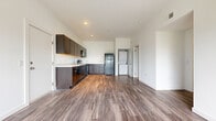 Located at 1240 Benchmark Park Dr in Columbus, Ohio, this single-floor residence offers three bedrooms and two bathrooms within a practical, well-organized layout. The open-concept kitchen and living area serves as the heart of the home, featuring durable wood-look flooring throughout. The kitchen is equipped with dark espresso cabinetry, a full suite of black appliances including a refrigerator, range, dishwasher, and built-in microwave, along with a double sink and light countertops. A stackable in-unit washer and dryer is conveniently tucked just off the kitchen. The living area is bright and open, with sliding glass doors that invite natural light and provide outdoor access. The three bedrooms feature neutral wall-to-wall carpeting and windows with blinds, offering comfortable, private retreats. The primary bedroom is a well-proportioned space with ample room for furnishings. One full bathroom includes a tub-shower combination with tile flooring, while the second bathroom features a walk-in shower stall, also with tile flooring and a clean, minimalist design. A hallway connects the bedrooms and bathrooms, and additional storage is available through a dedicated closet. The overall aesthetic is clean and neutral throughout.