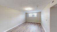 Located at 4646 Tamarack Blvd in Columbus, Ohio, this 2-bedroom, 1-bathroom unit offers a clean, updated interior with a practical single-floor layout. Wood-look luxury vinyl plank flooring runs consistently throughout the space, complemented by neutral warm-gray walls and crisp white trim, creating a cohesive and modern aesthetic.

The kitchen is a standout feature, showcasing white shaker-style cabinetry with matte black hardware, light granite countertops, a stainless steel sink with a black pull-down faucet, and black appliances including an electric range and refrigerator. The kitchen connects openly to the living area, supporting easy everyday flow.

Both bedrooms offer comfortable proportions with natural light provided by windows overlooking the surroundings. The primary bedroom is a well-sized retreat with textured ceilings and direct access via a clean white panel door. The second bedroom mirrors a similar feel with its own window and neutral finishes.

The full bathroom is neatly appointed with a white vanity, light countertop, a framed mirror, matte black fixtures and accessories, and a tub-shower combination. A hallway connects the main living areas efficiently, with built-in HVAC ventilation overhead. The overall ambiance is fresh, move-in ready, and thoughtfully updated throughout.