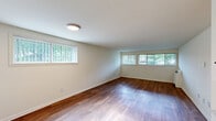 Located at 1420 Gregory St in Ypsilanti, Michigan, this one-bedroom, one-bathroom unit offers a well-organized and functional single-floor layout. Rich hardwood-style flooring runs throughout the entire space, creating a cohesive and warm aesthetic.

The combined kitchen and living area forms the heart of the unit. The living room features a row of wide windows dressed with vertical blinds, filling the space with natural light and offering views of surrounding greenery. A wall-mounted HVAC unit provides climate control. The open kitchen is positioned behind a peninsula counter with a clean white finish, providing additional workspace and casual dining potential. Stainless steel appliances — including a refrigerator and gas range — complement the white cabinetry and under-cabinet ventilation hood.

The bedroom is a comfortable, well-proportioned room equipped with a ceiling fan with light fixture, a window allowing natural light, and a built-in closet with panel doors for ample storage. The full bathroom includes a white vanity with stone-look countertop, a tiled shower-tub combination, and continued hardwood-style flooring. A dedicated closet provides additional storage elsewhere in the unit. The overall design is clean, neutral, and move-in ready.