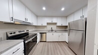 Located at 7512 Windbridge Dr in Sacramento, CA, this well-appointed 2-bedroom, 2-bathroom single-story residence offers a thoughtfully designed layout with clean, neutral finishes throughout. The living room serves as the heart of the home, featuring a tile-surround fireplace, soft carpet flooring, and a large window that fills the space with natural light and views of surrounding greenery. Durable wood-look vinyl flooring runs through the entryway and extends into the kitchen and utility areas, while plush carpet adds comfort in the bedrooms and living room. The kitchen is outfitted with white shaker-style cabinetry, matte black hardware, light stone countertops, a black gooseneck faucet, and stainless steel appliances including a dishwasher and refrigerator. A conveniently tucked in-unit laundry closet houses a full-size washer and dryer. The spacious primary bedroom includes its own en-suite bathroom featuring a vanity with ample cabinet storage and a separate water closet. Each bedroom offers a closet with built-in rods for organization. The second bathroom includes a clean white tub and shower combo. Throughout the home, textured walls, crisp white trim, and a soft greige color palette create a cohesive and move-in-ready atmosphere.