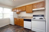 Located at 3817 George Washington Hwy. in Portsmouth, Virginia, this single-floor residence offers a straightforward and practical layout designed for comfortable everyday living. The living areas are finished with neutral-toned wall-to-wall carpeting and light-colored walls, creating a clean and cohesive atmosphere throughout. Multiple carpeted rooms provide flexible living and sleeping spaces, with one room featuring a closet with built-in shelving for additional storage. A larger carpeted room benefits from a window that invites natural light, adding brightness to the interior. The kitchen is equipped with warm oak cabinetry, light laminate countertops, a double-basin stainless steel sink, a dishwasher, and an electric range with an overhead ventilation hood, all set above durable hardwood-style flooring. The bathroom features a full-size soaking tub and shower combination, a window for natural ventilation, a vanity with sink, and tile flooring with a rich, earthy tone. Throughout the space, clean white trim and doors provide a consistent finish, and ceiling-mounted light fixtures ensure well-lit rooms. This residence offers a practical and move-in-ready environment suited for a variety of living arrangements.