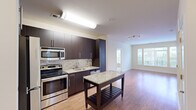 Located at 5750 Dow Ave in Alexandria, VA, this two-bedroom, three-bathroom residence offers a well-designed single-floor layout. The open-concept kitchen and living area serves as the heart of the home, featuring dark espresso cabinetry, stainless steel appliances including a range, microwave, and dishwasher, granite countertops with a mosaic tile backsplash, and a freestanding island with a granite top. Hardwood-style flooring flows throughout the main living areas, while track lighting and large windows allow ample natural light to fill the space. The living room is generously proportioned with wide windows that frame views of the surrounding neighborhood. Both bedrooms are carpeted and include windows with exterior views; the spacious primary bedroom benefits from its own dedicated closet with built-in wire shelving. A second carpeted bedroom provides comfortable additional living space. Three full bathrooms are finished with tile flooring, dark vanity cabinetry, and tub/shower combinations. Two closets provide practical storage throughout the unit. The clean, neutral palette and consistent finishes give the residence a cohesive, modern aesthetic suited for comfortable everyday living.