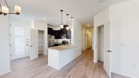Located at 12701 Eastlake Blvd in El Paso, TX, this single-story home offers four bedrooms, two bathrooms, and a well-designed layout that maximizes functionality. The open-concept kitchen and dining area serves as the heart of the home, featuring dark espresso cabinetry, granite countertops, stainless steel appliances, a double-basin sink, and a peninsula island illuminated by pendant lighting — ideal for both cooking and casual dining. Light wood-look vinyl plank flooring flows throughout the main living areas, creating a cohesive and easy-to-maintain aesthetic. The spacious living room benefits from natural light and ceiling fans, adding comfort throughout the year. The four bedrooms are carpeted for warmth and comfort, with several rooms featuring windows that bring in natural light and neighborhood views. The primary bedroom includes a generously sized walk-in closet with built-in shelving and hanging rods. Additional bedrooms offer closet storage as well. The two bathrooms are finished with granite vanity tops, dark cabinetry, framed mirrors, and tiled shower surrounds. An attached garage with an automatic opener provides secure parking and additional storage. The home combines practical finishes with a clean, modern design throughout.