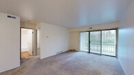 Located at 4616 Hunters Ridge Dr SE in Kentwood, Michigan, this single-floor unit offers a clean, functional layout with a neutral color palette throughout. The living area is a standout space, featuring plush carpet, smooth white ceilings, and a large sliding glass door flanked by vertical blinds that frame outdoor greenery and provide generous natural light. The open feel of this room makes it well-suited for a variety of furniture arrangements.

The galley-style kitchen is equipped with warm wood cabinetry, light stone-toned countertops, a stainless steel sink, and wood-look flooring. A full-size refrigerator and additional counter space provide practical storage and workspace. A ceiling fan in the adjacent area enhances airflow and comfort.

The bedrooms are carpeted and finished with neutral walls, offering a calm atmosphere. The primary bedroom includes a built-in closet with louvered bifold doors and a window with vertical blinds, allowing natural light while maintaining privacy. Additional bedroom space provides flexibility for various uses.

The bathroom is well-appointed with a wood-vanity, stone-look countertop, a large wall mirror, and a full tub-shower combination. Wood-look flooring ties the room together with a clean, cohesive finish throughout the unit.