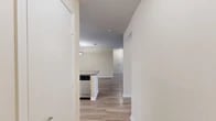 This single-story, three-bedroom, two-bathroom home in Jacksonville, Florida offers a well-organized and functional layout throughout. Wood-look flooring flows consistently across the entire home, lending a cohesive, clean aesthetic to every room.

The kitchen is a standout feature, equipped with stainless steel appliances — including a refrigerator, range, microwave, and dishwasher — complemented by white shaker-style cabinetry, dark granite-style countertops, and a sink. A hallway connects the kitchen to the open-plan dining and living room, which is bright and airy, with access to a private patio through double glass doors that invite natural light.

Each of the three bedrooms is comfortably sized, with the primary bedroom offering generous proportions. The bedrooms feature ceiling fans with light fixtures and include closet space. Seven closets throughout the home provide ample storage.

Both bathrooms are consistently appointed with white vanity cabinetry, dark countertops, and tub-shower combinations with tile surrounds. A dedicated laundry area and utility room add everyday practicality. Neutral warm-beige walls throughout the home create a calm, welcoming atmosphere well-suited to a variety of interior styles.
