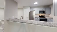 Located at 1523 Roswell Rd in Marietta, GA, this well-appointed 2-bedroom, 2-bathroom residence offers a thoughtfully designed single-floor layout. The open kitchen is a standout feature, showcasing granite countertops, gray shaker-style cabinetry, a subway tile backsplash, and a full suite of stainless steel appliances including a refrigerator, range, and microwave. A peninsula with an integrated sink and breakfast bar connects the kitchen to the main living area, which features durable wood-look flooring throughout.

Both bedrooms are carpeted and feature ceiling fans with light fixtures, neutral-toned walls, and windows that bring in natural light with views of surrounding greenery. Each bedroom is accompanied by a dedicated closet fitted with wire shelving systems for organized storage. The primary bedroom is generously sized and connects to its own closet space.

The two bathrooms are finished with wood-look flooring and clean, contemporary fixtures. One bathroom includes a tub-shower combo with full white subway tile surround and a built-in niche, while the second features accessibility-friendly grab bars. A connecting hallway ties the layout together efficiently, creating a functional and comfortable living environment.