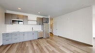 Located at 2132 Stokes Blvd in Cleveland's University Circle neighborhood, this thoughtfully designed one-bedroom, one-bathroom residence offers a clean, contemporary aesthetic throughout. Light-toned luxury vinyl plank flooring flows seamlessly across the entire unit, complementing the bright white walls and creating a cohesive, modern feel.

The open-concept kitchen and living area serves as the heart of the unit. The kitchen is outfitted with two-tone gray cabinetry featuring sleek black hardware, white quartz countertops, a white subway tile backsplash, and stainless steel appliances including a refrigerator, dishwasher, and over-the-range microwave with a built-in cooktop. The adjoining living area is bathed in natural light from a large floor-to-ceiling window offering open city views.

The bedroom is a composed, quiet space with its own oversized window framing urban Cleveland scenery, providing ample natural light. Two closets offer generous storage throughout the unit, and a dedicated laundry area adds everyday convenience.

The bathroom features a clean, minimalist design with gray vanity cabinetry, a white countertop, a large mirror, and accessible grab bars. The space maintains the same light flooring found throughout, tying the design together cohesively.