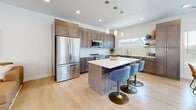 Located in Draper, Utah, this contemporary multi-floor home offers a well-designed layout spread across three levels. The entry level provides a welcoming introduction to the space, while the main floor serves as the heart of the home, featuring an open-concept living room, dining area, and kitchen. The living room is bright and airy, with light hardwood flooring, recessed lighting, and French doors that open to an outdoor area, inviting natural light throughout. The kitchen is equipped with warm taupe shaker cabinetry, white quartz countertops, stainless steel appliances, and a undermount sink — combining functionality with a clean, modern aesthetic. The dining area benefits from large windows with views of the surrounding neighborhood. Upstairs, two well-proportioned bedrooms offer comfortable retreats, each featuring light hardwood floors, ample natural light, and closet space. A dedicated office with a ceiling fan and large window provides an ideal workspace. The home includes three full bathrooms: one features a glass-enclosed walk-in shower with large-format tile, while another offers a soaking tub and shower combination — both finished with gray wood-tone vanities and white countertops. Consistent light hardwood flooring and a neutral color palette tie the entire home together in a cohesive, modern style.