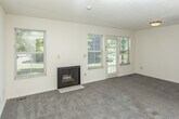 Located at 3145 Lohr Rd in Ann Arbor, MI, this three-floor home offers a well-distributed layout across its main level, upper floor, and basement. The main living area features plush carpeting, a textured ceiling, and a fireplace framed by multiple windows and a glass-paned exterior door that invites abundant natural light and outdoor views of surrounding greenery. The kitchen is equipped with warm oak cabinetry, ample counter space, and a gas range with overhead ventilation, providing a functional cooking environment. Carpeted bedrooms are found on the upper level, where vaulted ceilings lend a sense of openness. The home includes multiple bathrooms outfitted with wood-look flooring, white vanities with mirrored medicine cabinets, and a full tub-shower combination. A half bath with a single vanity is also present. The unfinished basement offers generous open space with exposed wood-beam ceilings, visible ductwork, and concrete flooring, presenting versatile potential for storage or future development. An attached single-car garage with an automatic door opener completes the home, adding practical convenience to this multi-level Ann Arbor residence.