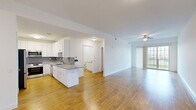 This 2-bedroom, 1-bathroom residence at 250 Celebration Ct in Middletown, Delaware offers a well-designed, single-floor layout with a clean, modern aesthetic. Warm hardwood-style flooring flows continuously throughout every room, creating a cohesive and inviting atmosphere. The open-concept kitchen and living area serves as the heart of the home, offering a generous, light-filled space ideal for both everyday living and entertaining. The kitchen is outfitted with white shaker-style cabinetry, granite countertops, a hexagonal tile backsplash, stainless steel appliances including a gas range and built-in microwave, and a peninsula that provides additional workspace and seating. The living room is bathed in natural light from a large sliding glass door that opens to an outdoor area, and is complemented by a ceiling fan overhead. Both bedrooms are comfortably sized, featuring neutral white walls, ceiling fans or overhead lighting, and ample natural light from windows with blinds. The primary bedroom is particularly spacious. The bathroom continues the home's modern design with a granite-topped vanity, white cabinetry, wood-style flooring, and a tub-shower combination with marble-style tile surround. Hallways connect the spaces efficiently, completing this well-appointed and move-in-ready residence.