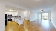This 2-bedroom, 1-bathroom residence at 250 Celebration Ct in Middletown, Delaware offers a well-designed, single-floor layout with a clean, modern aesthetic. Warm hardwood-style flooring flows continuously throughout every room, creating a cohesive and inviting atmosphere. The open-concept kitchen and living area serves as the heart of the home, offering a generous, light-filled space ideal for both everyday living and entertaining. The kitchen is outfitted with white shaker-style cabinetry, granite countertops, a hexagonal tile backsplash, stainless steel appliances including a gas range and built-in microwave, and a peninsula that provides additional workspace and seating. The living room is bathed in natural light from a large sliding glass door that opens to an outdoor area, and is complemented by a ceiling fan overhead. Both bedrooms are comfortably sized, featuring neutral white walls, ceiling fans or overhead lighting, and ample natural light from windows with blinds. The primary bedroom is particularly spacious. The bathroom continues the home's modern design with a granite-topped vanity, white cabinetry, wood-style flooring, and a tub-shower combination with marble-style tile surround. Hallways connect the spaces efficiently, completing this well-appointed and move-in-ready residence.