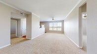 This single-floor, 2-bedroom, 2-bathroom residence features a thoughtfully designed layout that balances comfort and functionality. The spacious living area is finished with plush neutral carpeting, crown molding, and a ceiling fan, while a large window invites generous natural light and outdoor views, creating an open and airy atmosphere.

The kitchen is well-equipped with rich dark wood cabinetry, warm countertops, black appliances including a refrigerator, stove, and dishwasher, and durable hardwood-style flooring. A breakfast bar peninsula separates the kitchen from the living area, and a windowed door provides additional natural light and exterior access.

The primary bedroom is a generously sized retreat featuring a ceiling fan, plush carpeting, crown molding, and a window with outdoor views. A dedicated closet adds practical storage. The second bedroom is similarly comfortable, with carpet flooring and a window that brings in natural light.

Both bathrooms are finished consistently, each featuring a tub-shower combination with tiled surround, dark wood vanity cabinetry, light countertops, and hardwood-style flooring. Two hallways and two closets throughout the residence provide ample circulation and storage. The neutral color palette and cohesive finishes lend a clean, move-in ready feel to the entire space.