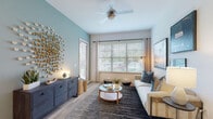 This thoughtfully designed two-bedroom, two-bathroom residence in Jacksonville, FL delivers a seamless blend of modern style and everyday functionality across a single floor. The open-concept living area features light wood-look flooring, vaulted ceilings with a ceiling fan, and large windows dressed with blinds and curtain panels that invite generous natural light. A striking accent wall in soft teal adds a coastal character to the living room, which flows comfortably for both relaxing and entertaining. The kitchen is a standout feature, showcasing light wood flat-panel cabinetry, a classic subway tile backsplash, stainless steel appliances, and an expansive granite-topped island with an undermount sink — ideal for meal prep and casual dining. Both bedrooms are well-proportioned, with plush carpeting, large windows, and ample natural light. The primary bathroom offers a wide vanity with granite countertops, wood cabinetry with matte black hardware, and light wood-look tile flooring. The second bathroom mirrors this refined aesthetic with a tub-shower combination. Throughout, the finishes are cohesive and contemporary, creating a clean, inviting atmosphere suited to modern living in Jacksonville.