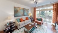 This single-floor residence offers a thoughtfully designed layout that balances comfort and functionality across its key living areas. The living room serves as the heart of the home, featuring warm hardwood flooring, track lighting, and a large window with balcony access that floods the space with natural light and provides views of lush outdoor greenery. Bold abstract artwork and vibrant accent colors give the room an inviting, contemporary character.

The kitchen is outfitted with dark espresso cabinetry, granite countertops, and a full suite of stainless steel appliances, including a refrigerator, range, and over-the-range microwave. Hardwood flooring continues throughout, and a breakfast bar provides additional prep and dining space.

The residence includes two bedrooms, each carpeted and well-proportioned. The primary bedroom features a bold accent wall, access to a walk-in closet, and an en-suite bathroom. The second bedroom offers a large window with outdoor views, providing a bright and serene retreat.

Both bathrooms are finished with granite-topped dark vanities and tiled flooring. The bathrooms include shower-tub combinations with clean, neutral tile surrounds. Overall, the space presents a cohesive design with neutral walls, quality finishes, and abundant natural light throughout.