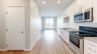 This well-appointed one-bedroom, one-bathroom residence in Denver, CO offers a thoughtfully designed single-level layout that maximizes functionality and comfort. The open-concept kitchen and living area serves as the heart of the unit, featuring crisp white cabinetry with gold-toned hardware, granite-look countertops, and a full suite of stainless steel appliances including an electric range, built-in microwave, and refrigerator. Light luxury vinyl plank flooring runs throughout the main living areas, lending a clean, contemporary aesthetic that ties the space together seamlessly.

The living area extends toward a large window that fills the room with natural light, creating an airy, open atmosphere. The bedroom offers a cozy retreat with plush carpeting and a generously sized window with blinds, providing both comfort and privacy. A dedicated closet with built-in shelving adds practical storage solutions.

The bathroom is finished with granite-look countertops, a single vanity with a large mirror, and clean, modern fixtures. Wood-look flooring continues into the bathroom, maintaining a cohesive design throughout. Recessed lighting and neutral tones across all rooms contribute to a bright, modern ambiance well-suited for urban living in the heart of Denver.