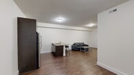 This single-floor unit offers a thoughtfully designed layout with 3 bedrooms and 3 bathrooms, making it an ideal space for shared or family living. The open-concept kitchen and living area serves as the heart of the unit, featuring rich dark-wood cabinetry, stainless steel appliances including a refrigerator, range, and microwave, and a granite-topped island with bar seating for three — perfect for casual dining or entertaining. Wood-look flooring runs throughout the main living area, adding warmth and continuity to the space.

The living room is connected seamlessly to the kitchen, creating a generous combined area with clean white walls and flush ceiling lighting. Each of the three bedrooms is carpeted for comfort and offers a quiet, functional retreat. The primary bedroom includes direct access to adjoining rooms, while the additional bedrooms are well-sized for use as sleeping or study spaces.

All three bathrooms are finished with floor-to-ceiling neutral tile, glass-enclosed walk-in showers, wall-mounted vanities, and framed mirrors, presenting a clean and contemporary aesthetic. A hallway connects the private areas of the unit to the shared living spaces, ensuring a practical and efficient flow throughout. The overall design is modern, understated, and functional.