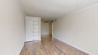 Located at 2800 W T C Jester Blvd in Houston, TX, this single-floor, 2-bedroom, 1-bathroom unit offers a practical and comfortable layout. Throughout the living areas and bedrooms, warm wood-look laminate flooring creates a cohesive and inviting atmosphere, complemented by neutral toned walls and clean white trim and baseboards.

The primary bedroom is a generously sized retreat, featuring a ceiling fan, built-in open shelving, and a closet for convenient storage. The second bedroom is equally comfortable, boasting a ceiling fan and a window that invites natural light and views of the surrounding greenery. Additional closet space is found throughout the unit, ensuring ample storage options.

The kitchen is efficiently designed with a galley-style layout, offering white cabinetry, dark granite-style countertops, a double-basin sink, and white appliances, including a refrigerator, stove, and dishwasher. The marble-look tile flooring adds a clean, polished touch to the space.

The bathroom is a standout feature, showcasing large-format marble-look wall tiles surrounding a full soaking tub with a shower, paired with matching floor tiles and a dark granite-top vanity. A hallway connects the rooms, creating a smooth and functional flow throughout this well-appointed Houston residence.