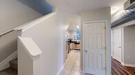 Located at 111 Cochran Rd in Clemson, SC, this two-story home offers five bedrooms and four bathrooms across a generously sized layout spread over two floors. The main floor contains the majority of the living space, including an open-concept living, dining, and kitchen area. The living room features striking exposed ductwork, soaring ceilings, and rich hardwood-style flooring, lending an industrial-chic ambiance. A white brick accent wall anchors the dining area, which opens seamlessly to the kitchen through a peninsula counter with pendant lighting above. The kitchen is well-appointed with light maple cabinetry, dark granite countertops, stainless steel appliances including a refrigerator, range, and microwave, and tile flooring accented by a checkered rug. The bedrooms are carpeted and well-proportioned, each offering closet space and natural light from windows. The spacious primary bedroom provides ample room for both rest and a dedicated workspace. The four bathrooms are finished with granite-topped vanities, tile flooring, and walk-in showers. A dedicated laundry area, multiple hallways, and three closets add to the home's practical functionality. The upper floor offers additional private space, completing this well-rounded and versatile home.