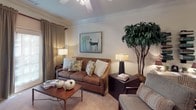 Located at 4060 Washington Rd in Augusta, Georgia, this single-story residence offers a thoughtfully designed layout across a generous, connected floor plan. The living room serves as the heart of the home, featuring plush carpeting, crown molding, a ceiling fan, and warm, inviting décor. Large windows allow natural light to filter in, creating a bright and comfortable atmosphere.

The galley-style kitchen is well-equipped with ample warm-toned cabinetry extending to the ceiling, granite-look countertops, black appliances including a range, microwave, refrigerator, and dishwasher, complemented by track lighting and easy-care tile flooring.

The bedrooms are generously proportioned, each with plush carpet, ceiling fans, and wide windows that bring in natural light. The primary bedroom provides a calm, restful retreat, while additional bedrooms offer flexibility for guests or a home office.

The bathrooms are clean and functional, with one featuring a tub-shower combination with built-in shelving and tile surround, and another offering a full vanity with ample cabinet storage and a tub-shower combination. A carpeted hallway with vaulted ceilings, framed wall art, and a rich wood dresser with mirror connects the spaces, adding a polished, cohesive feel throughout the home.
