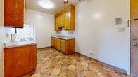 Located at 2615 Marina Blvd in San Leandro, CA, this one-bedroom, one-bathroom unit offers a well-organized layout across a single floor. The kitchen and dining area are combined into one functional space, featuring warm honey-toned wood cabinetry with ample upper and lower storage, granite-look countertops, white appliances including an electric range and refrigerator, and a distinctive earth-toned hexagonal tile floor that extends throughout the kitchen and bathroom. A ceiling fan with light fixture serves the kitchen area. The kitchen flows openly into the living room, which is finished with plush light-colored carpeting and features a sliding glass door that provides natural light and access to an outdoor area. The bedroom offers comfortable proportions, carpeted floors, a dedicated closet, and a window that allows in natural light. A second closet provides additional storage elsewhere in the unit. The bathroom is equipped with a wood-toned vanity, a mirror cabinet, and a shower-tub combination with sliding glass doors, continuing the hexagonal tile flooring seen throughout. The entryway features a parquet-style floor, providing a warm welcome into the unit. Overall, the space presents a functional and cohesive design with consistent finishes throughout.