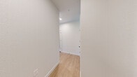 Located at 100 E Second Ave in Longmont, CO, this thoughtfully designed two-bedroom, two-bathroom residence offers a clean, contemporary aesthetic across a single floor. Light wood-tone flooring flows through the main living areas, complemented by crisp white walls and recessed lighting that create a bright, welcoming atmosphere.

The kitchen is a standout feature, showcasing a striking combination of white upper cabinetry and warm natural wood lower cabinets, all anchored by granite countertops. A large island with seating provides an ideal space for dining and entertaining, while stainless steel appliances, a tile backsplash, and a window overlooking the outdoors complete the modern culinary space.

The living area opens to a private balcony through expansive sliding glass doors, allowing abundant natural light and outdoor views to pour in. The spacious primary bedroom features plush carpeting, a ceiling fan, and generous closet space. Both bathrooms mirror the home's cohesive design language, featuring wood-toned vanities, granite countertops, and black matte fixtures — the primary bath offering a dual-sink vanity with framed mirrors.

Additional highlights include an in-unit laundry area and ample closet storage throughout, making this a well-appointed and functional home.