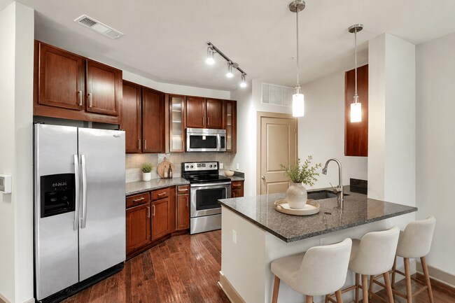 Una cocina con refrigerador, estufa y horno. - ICON at Dulles