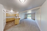 Located at 3502 Bluebell Ln in Jackson, MI, this one-bedroom, one-bathroom unit offers a well-organized single-floor layout designed for comfortable everyday living. The open-concept main area seamlessly connects the kitchen, dining, and living spaces into one cohesive room. The kitchen is outfitted with light maple cabinetry, ample upper and lower storage, a gas range, built-in microwave, and a refrigerator, all set atop wood-look flooring. A peninsula counter provides an easy transition into the combined dining and living area, which features neutral carpet, a textured ceiling, and a sliding glass door that floods the space with natural light and leads to a private patio with pleasant outdoor views. The bedroom offers a comfortable footprint with carpet flooring, a window with natural light, and access to a dedicated walk-in closet with built-in shelving. The bathroom features wood-look flooring, a vanity with light maple cabinetry, and a clean, functional layout. Additional conveniences include a laundry area, utility room, and multiple closets throughout, making storage straightforward and practical. The unit's bright, neutral palette and functional design make it an efficient and inviting living space.